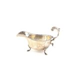 George V silver sauce boat, Birmingham 1933, 18 cms, on three shell feet with beaded borders,