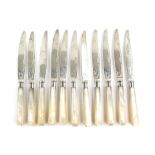 George V set of eleven tea knives and twelve forks with engraved decoration and mother of pearl