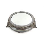 Silver plated mirrored cake stand with moulded shell and scroll decoration on three shaped feet,
