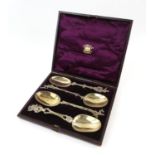 Cased set of four Continental silver serving spoons each with a different designed stem and figural