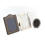 Three silver photo frames of varied designs and dates