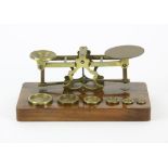 Brass postal weighing scales on rosewood stand complete with 6 weights from 1/8 an oz to 4 ozs