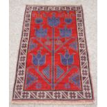 Afghan Belouch full pile tribal rug, with floral design on a red ground within geometric border,