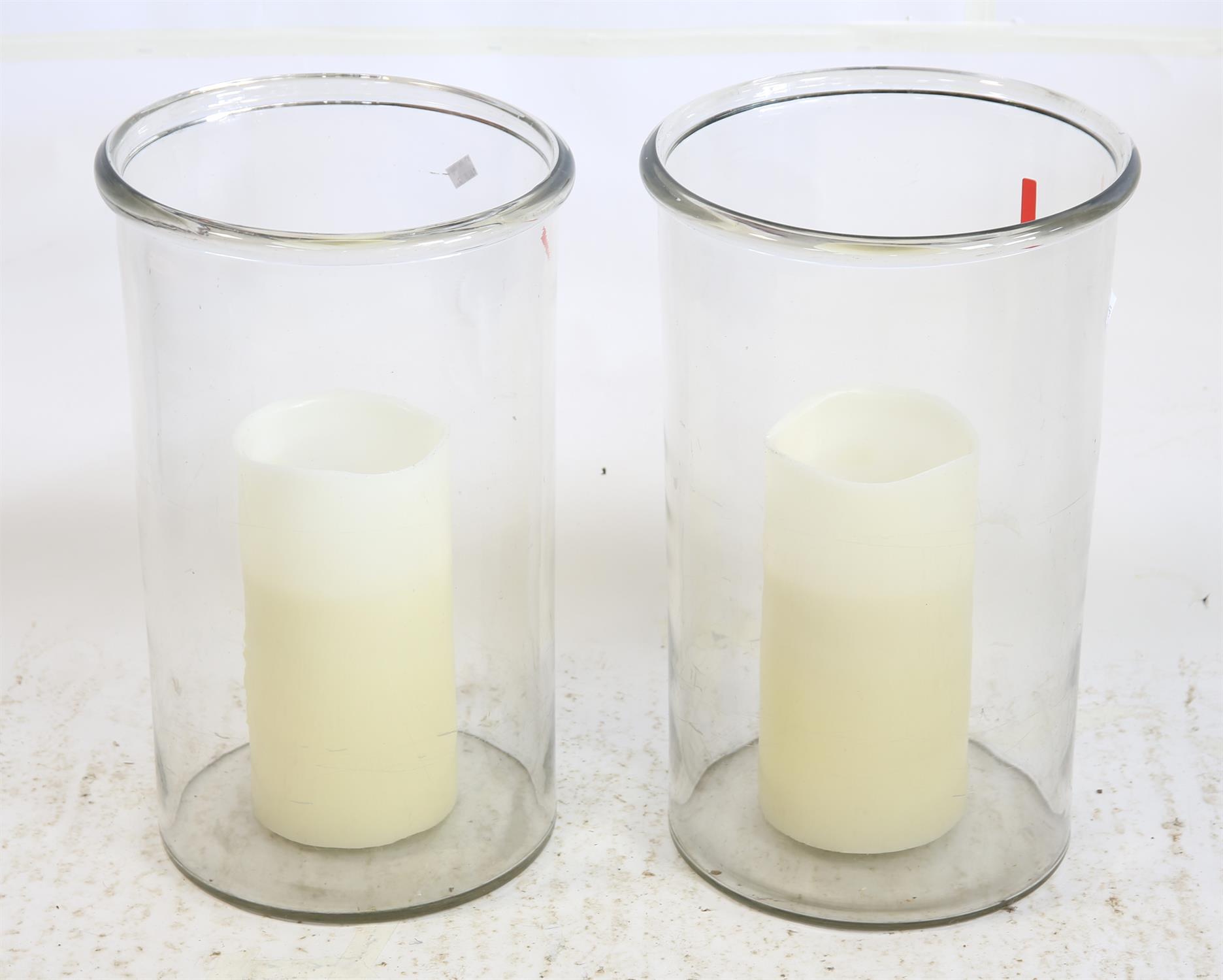 A pair of glass cylindrical hurricane candle holders h51cm d 31cm with faux candles to interior