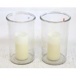 A pair of glass cylindrical hurricane candle holders h51cm d 31cm with faux candles to interior