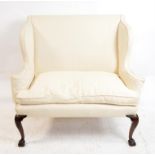 George II mahogany framed small sofa with stuffed cream upholstery on acanthus carved cabriole legs