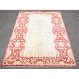 Agra carpet with floral motifs on a cream ground within red ground border with floral design,