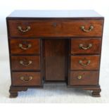 19th century mahogany kneehole desk with long drawer over cupboard flanked by three drawers on ogee