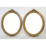 Pair of early 20th century gilt framed oval mirrors with moulded foliate and beaded decoration,