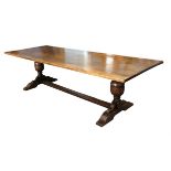 20th century oak refectory style dining table on carved twin-end supports and stretcher,