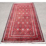 Persian Belouch full pile red and black ground carpet, repeating motifs on a red ground within