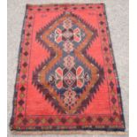 Afghan Belouch full pile nomadic rug, with twin diamond medallions on a red ground, 138 x 88cm