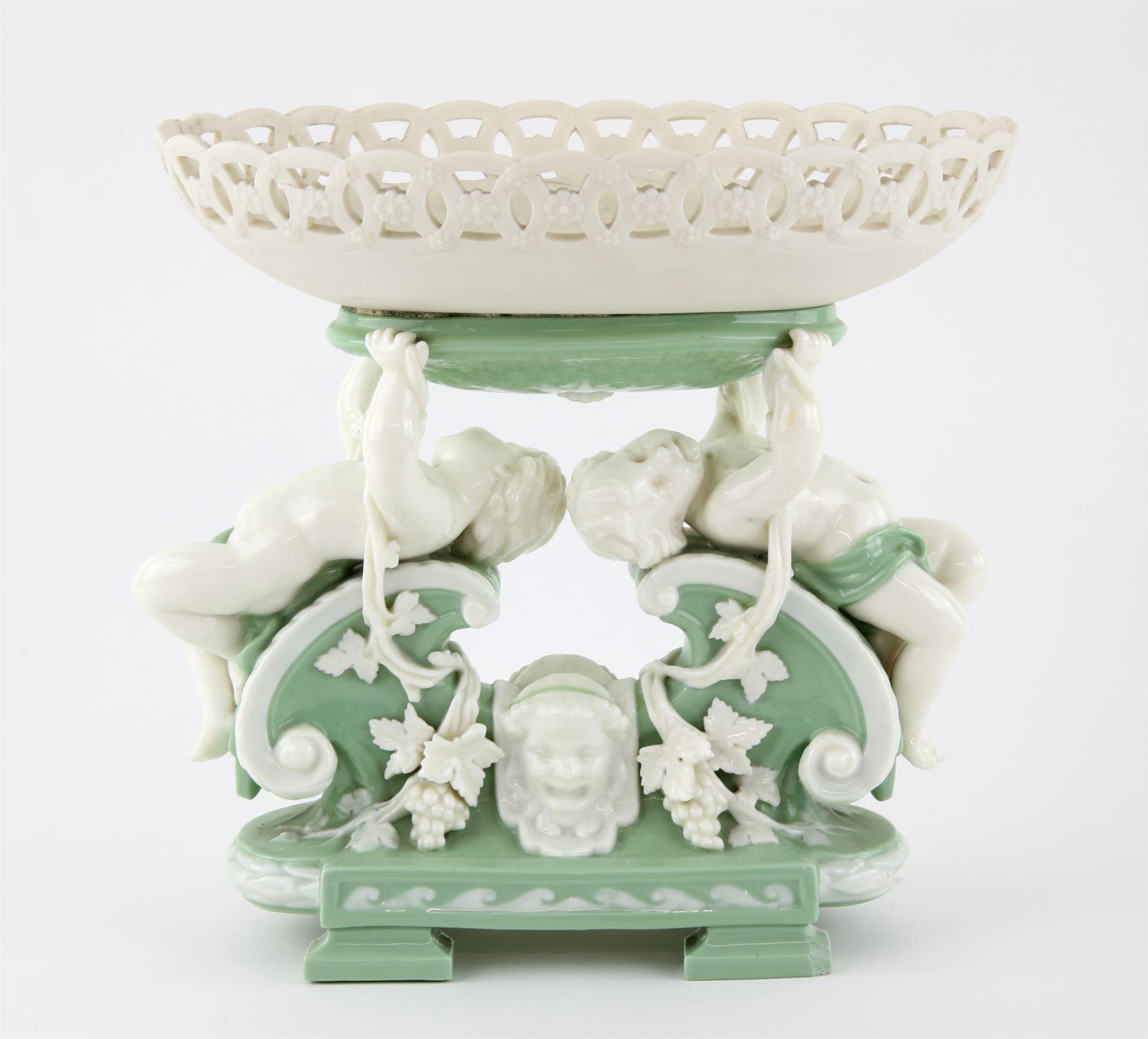 Mintons pale green and white glazed figural centrepiece, two putti holding up an oval pierced