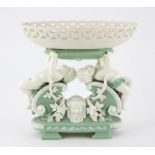 Mintons pale green and white glazed figural centrepiece, two putti holding up an oval pierced