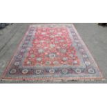 Persian red ground carpet, palmettes and flowerheads on red ground within scrolling floral design