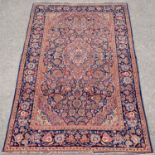 Persian blue ground rug with central floral medallion and floral motifs within a floral border,