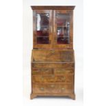 Early 20th century walnut bureau bookcase, glazed doors and two candle slides above fall front with