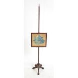 Regency mahogany pole screen, the screen painted on fabric with grapes in a basket on three carved