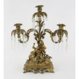 Early 20th century gilt metal figural three light candelabra with scroll arms, a young man and