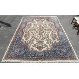 Persian Kirman carpet with floral design on a cream ground, within blue ground floral border,