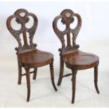 Pair of early Victorian mahogany hall chairs the backs carved and pierced with foliate scrolls