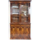 Victorian flame mahogany bookcase, with moulded cornice above scrolling floral carving flanking two