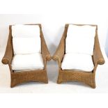 Pair of rattan conservatory armchairs, with shaped arms and cream upholstered cushions,