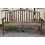 Teak garden bench of slat construction, on square legs joined by stretchers, h93cm w150cm d59cm