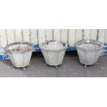 Set of three octagonal reconstituted stone planters of tapering form, on scrolling metal feet,