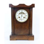 Oak cased mantel clock, the two train movement striking on a bell, the white enamel dial with