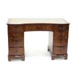 Mahogany oval topped low table, on turned support and splayed legs with brass caps and castors,