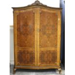 Modern walnut veneered wardrobe, with three doors revealing clothes rail and slides,