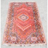 Persian rug with central diamond medallion and animals and stylised floral motifs on a red ground,