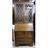 Oak bureau bookcase with leaded glazed doors over two short and three long drawers on bracket feet,