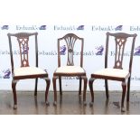 Four reproduction mahogany dining chairs with pierced splat backs and cream drop in seats,