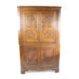 Large 19th century oak corner cabinet, with dentil cornice over four panelled doors carved with