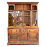 20th century oak dresser with open shelves above glazed doors, three short drawers and cupboards on