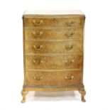Modern burr walnut veneered serpentine chest of five drawers, with scrolling floral carved edges on