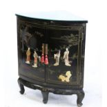 Chinese black lacquered cupboard with two doors overlaid with figures in garden setting,