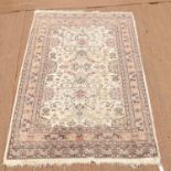 Persian rug with stylised floral design on a cream ground within floral border, bearing signature