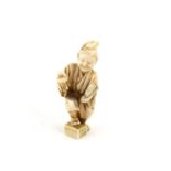 A Japanese Okimono , Meiji Period Circa 1880 Carved Ivory depicting a man holding a bird and a fan