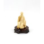 A Japanese Okimono , Meiji Period Carved Ivory representing a a sitting man.  with wood stand . 8.