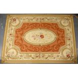 Pair of Aubusson rugs, with central oval floral medallion on a terracotta ground within cream and