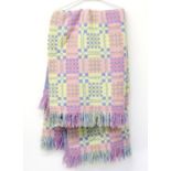 Two matching Welsh blankets woven in pastel colours, lavender, pink, yellow and white with