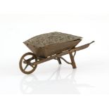 A brass Avery needle packet case, formed as a 'Wheel Barrow', hinged floral rose cover,