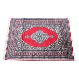 Persian Insaryam red ground rug with central medallion and stylised floral motifs within floral
