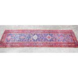 Persian runner with five diamond medallions and stylised floral motifs on a blue ground within