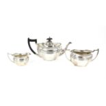 George V silver three piece tea service, Chester 1911, of serpentine form with ebonised handle and