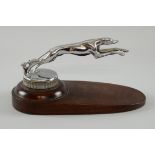 A 'Leaping Greyhound' Car Mascot on a knurled radiator cap, mounted on a wood base,