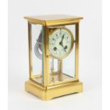 Early 20th century French brass mantel clock, with bevelled glass sides, enclosing an enamelled